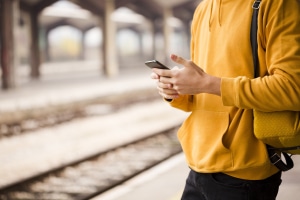 Voyageur dans une gare avec un smartphone